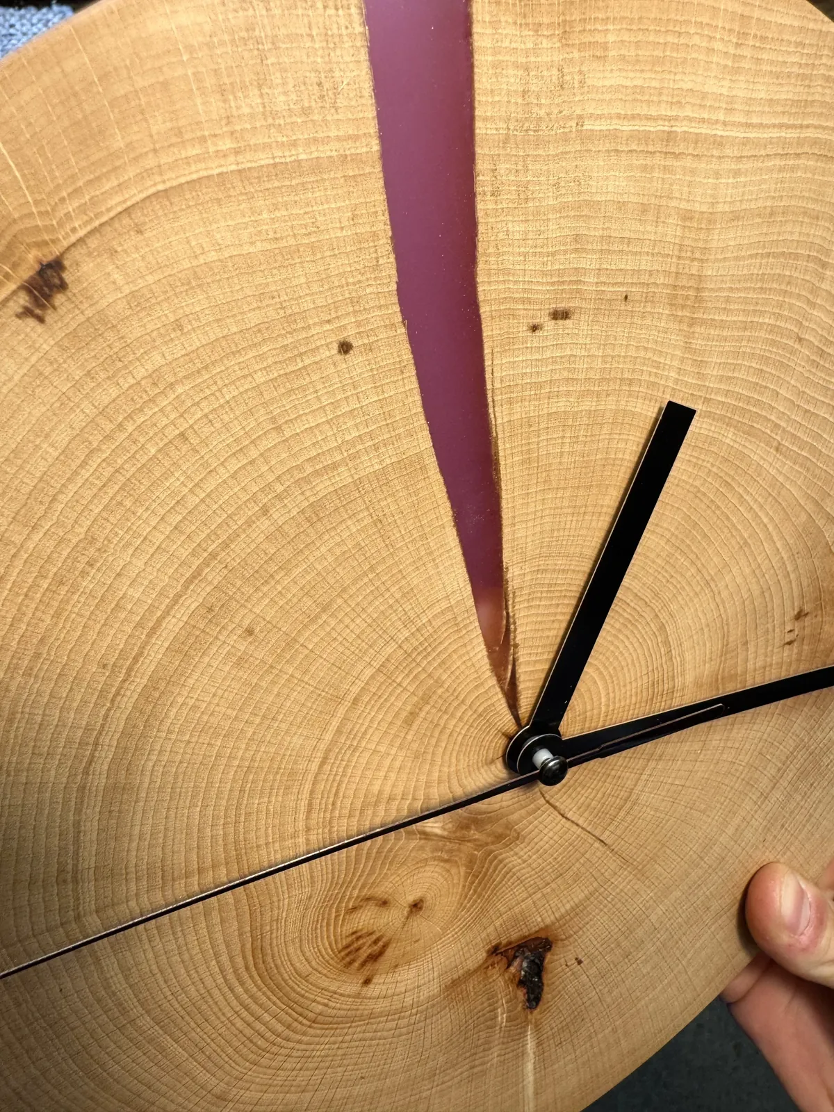 Horloge murale taillée dans une rondelle de tronc, veine de résine violette et aiguilles noires